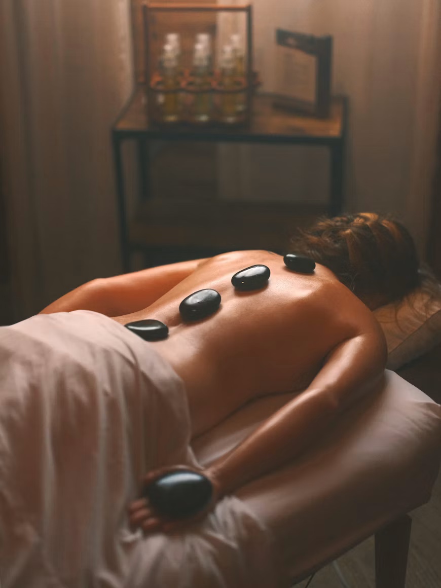 Hot stone-massage i varmt ambra-ljus — kroppsvård Studio Mira